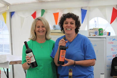 2 women holding wine bottles