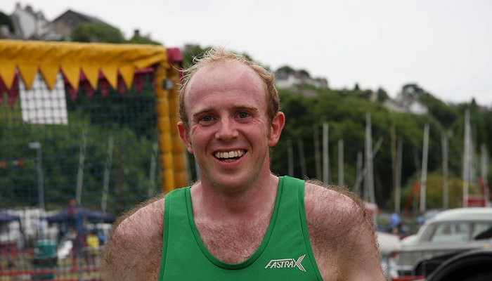 man smiling in a green vest
